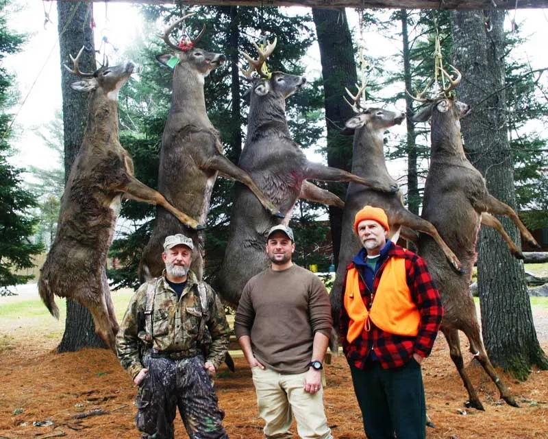 Five harvested whitetail deer, hunters and Maine Hunting Guide Jim Yearwood.